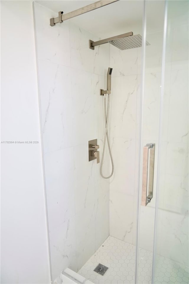 bathroom featuring a marble finish shower