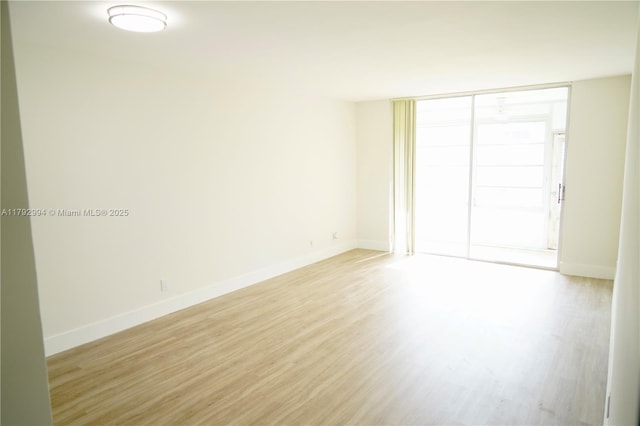 unfurnished room with baseboards and light wood-type flooring