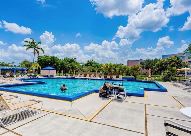 community pool featuring fence and a patio