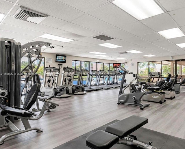 exercise room featuring visible vents, a paneled ceiling, and wood finished floors
