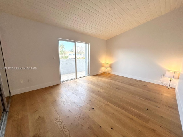 unfurnished room with baseboards, light wood finished floors, and wood ceiling