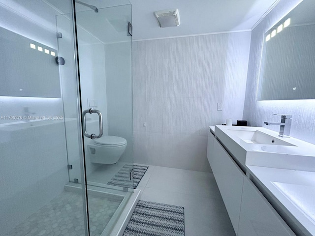 bathroom with double vanity, tile patterned floors, a shower stall, and a sink