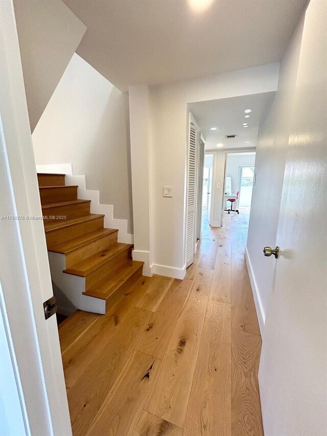 stairway with baseboards and hardwood / wood-style floors