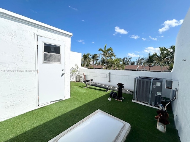 view of yard with central AC unit and a fenced backyard
