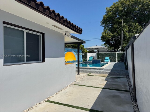 729 E 23rd St, Hialeah, FL 33013 - view of property exterior featuring a fenced backyard, stucco siding, a fenced in pool, a patio area, and a tile roof