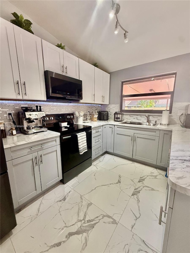 14712 SW 84th Ter, Miami, FL 33193 - kitchen featuring track lighting, marble finish floor, stainless steel microwave, decorative backsplash, and black range with electric cooktop