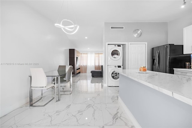 14712 SW 84th Ter, Miami, FL 33193 - kitchen featuring fridge with ice dispenser, stacked washing machine and dryer, a chandelier, light marble finish floors, and white cabinets