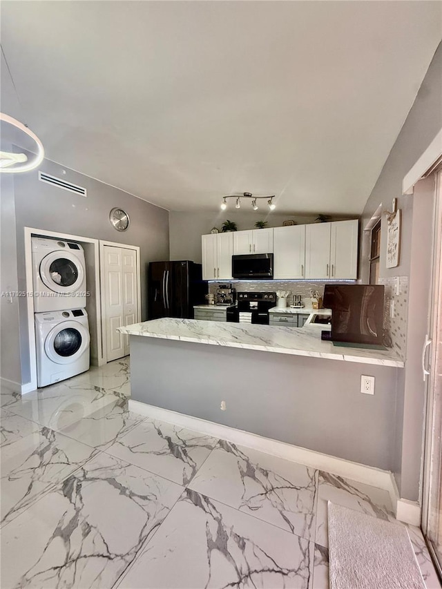 14712 SW 84th Ter, Miami, FL 33193 - kitchen with stacked washer / drying machine, black appliances, a peninsula, and white cabinetry
