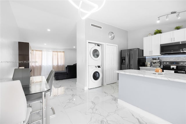 14712 SW 84th Ter, Miami, FL 33193 - kitchen with stainless steel appliances, stacked washer / drying machine, white cabinetry, light marble finish floors, and light stone countertops