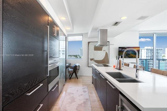 kitchen with island exhaust hood, a sink, and modern cabinets