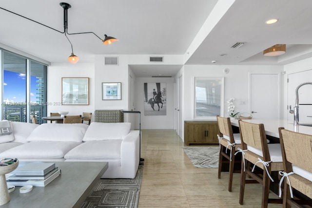 living area featuring recessed lighting, visible vents, and floor to ceiling windows