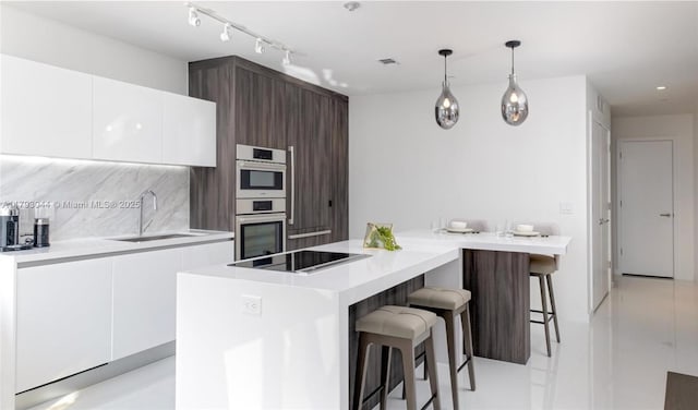 851 NE 1st Ave Unit 2604, Miami, FL 33132 - kitchen featuring modern cabinets, a breakfast bar area, white cabinetry, black electric stovetop, and light countertops