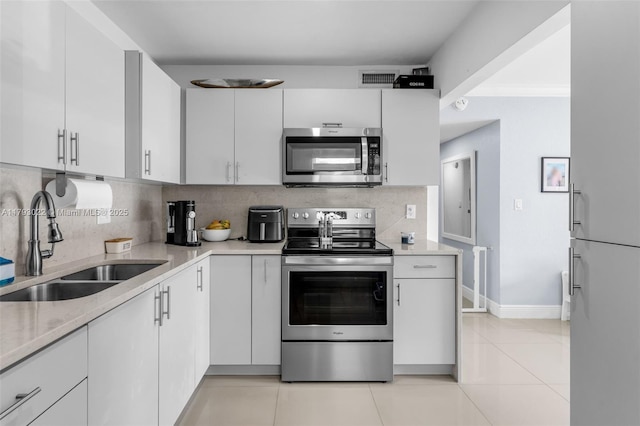 kitchen with visible vents, a sink, tasteful backsplash, and stainless steel appliances
