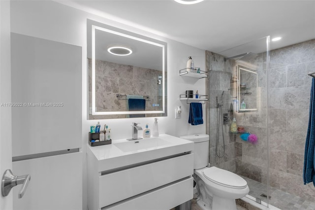 bathroom featuring vanity, a shower stall, and toilet