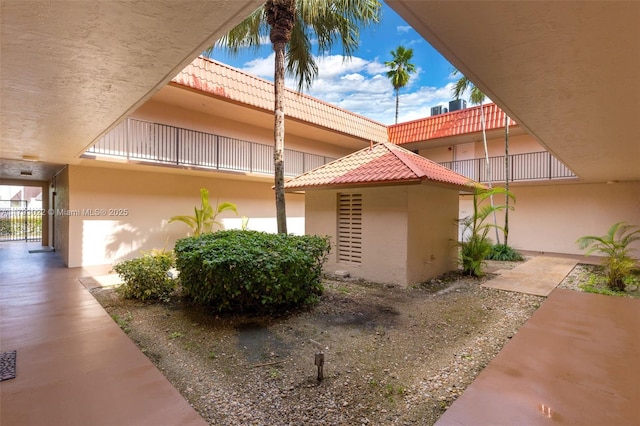 view of side of property featuring a tile roof and stucco siding