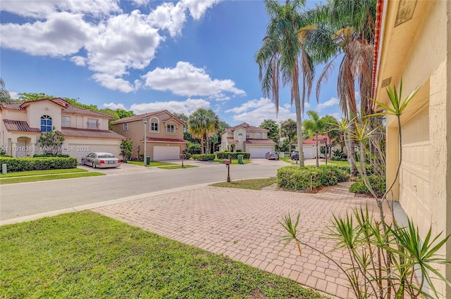 view of yard with a garage, decorative driveway, and a residential view
