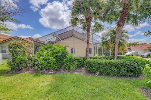 view of yard featuring a lanai and fence