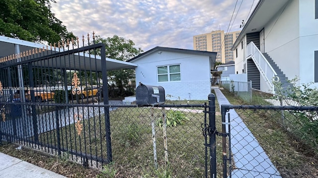 view of side of home featuring brick siding, fence, and stucco siding