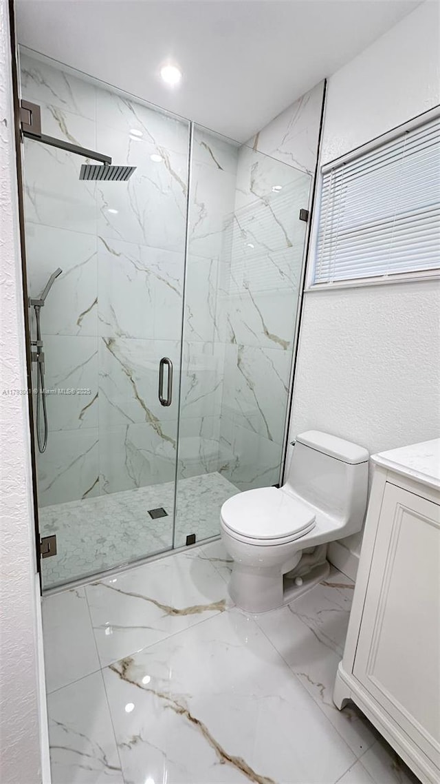 full bathroom featuring toilet, a marble finish shower, marble finish floor, and vanity