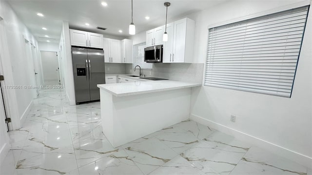 kitchen with baseboards, a sink, marble finish floor, and appliances with stainless steel finishes
