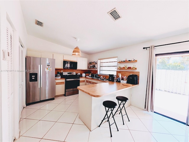 11212 SW 58th Cir, Cooper City, FL 33330 - kitchen featuring a kitchen breakfast bar, visible vents, appliances with stainless steel finishes, a peninsula, and lofted ceiling