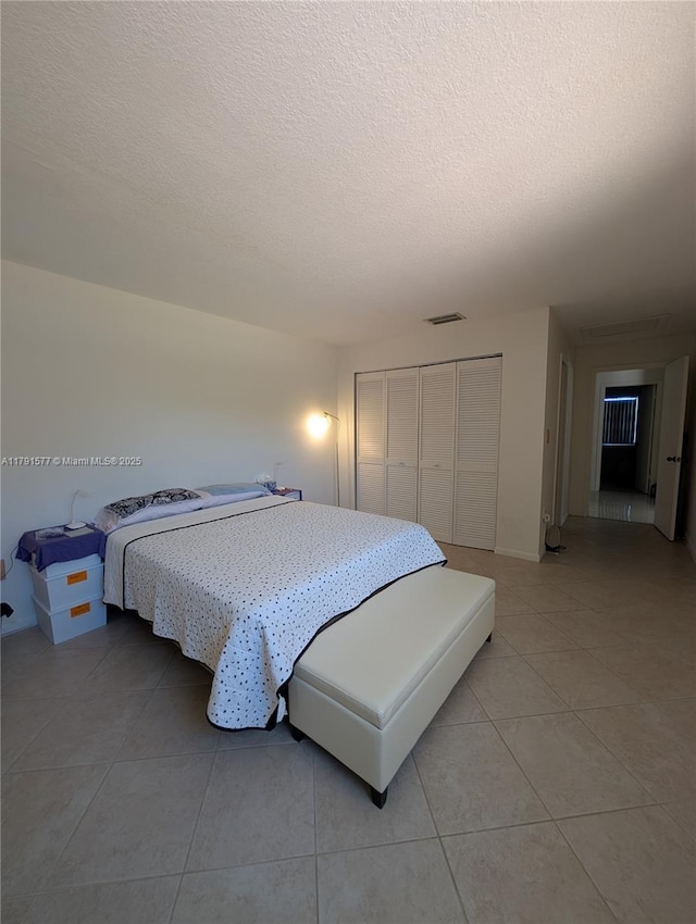 11212 SW 58th Cir, Cooper City, FL 33330 - bedroom with a closet, a textured ceiling, light tile patterned flooring, and visible vents