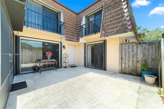 720 7th Ln, Green Acres, FL 33463 - rear view of property with a patio area, mansard roof, fence, a balcony, and stucco siding