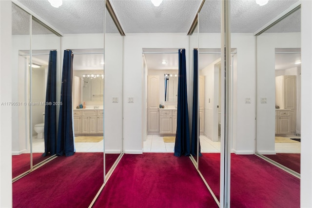 720 7th Ln, Green Acres, FL 33463 - interior space featuring connected bathroom, a textured ceiling, carpet flooring, and a closet