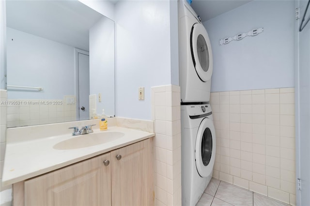 720 7th Ln, Green Acres, FL 33463 - bathroom with stacked washer and dryer, tile walls, wainscoting, tile patterned floors, and vanity