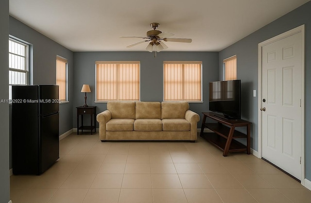 living area with baseboards and ceiling fan