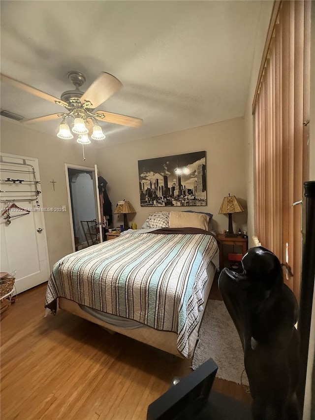 bedroom with visible vents, ceiling fan, and wood finished floors