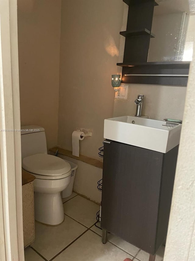 half bath with vanity, tile patterned floors, and toilet