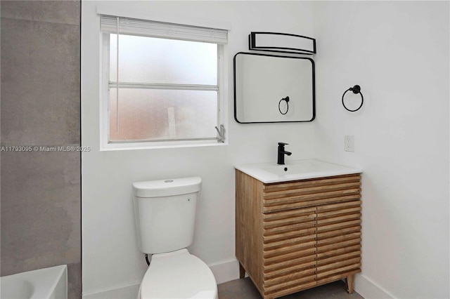 full bath featuring vanity, baseboards, toilet, and a bath