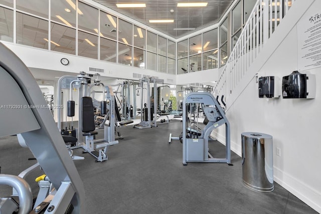 gym featuring baseboards, visible vents, and a high ceiling