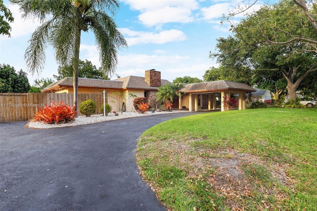 8261 SW 186th St, Cutler Bay, FL 33157 - view of front facade with stucco siding, fence, a chimney, driveway, and a shingled roof
