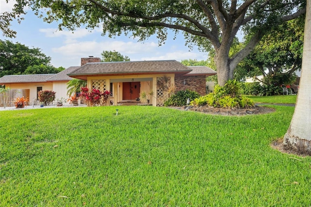 single story home featuring a chimney and a front yard