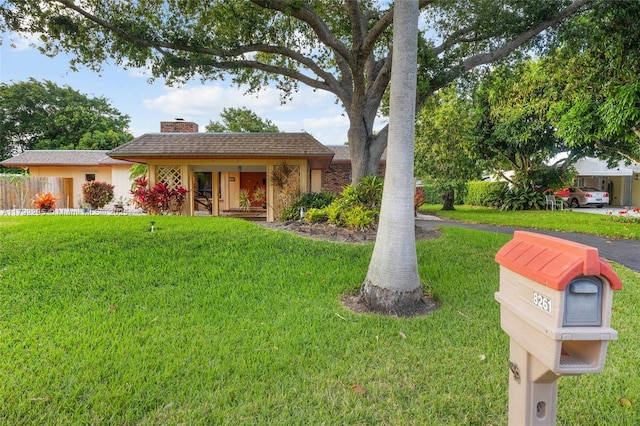 view of front of house with a front lawn and a chimney
