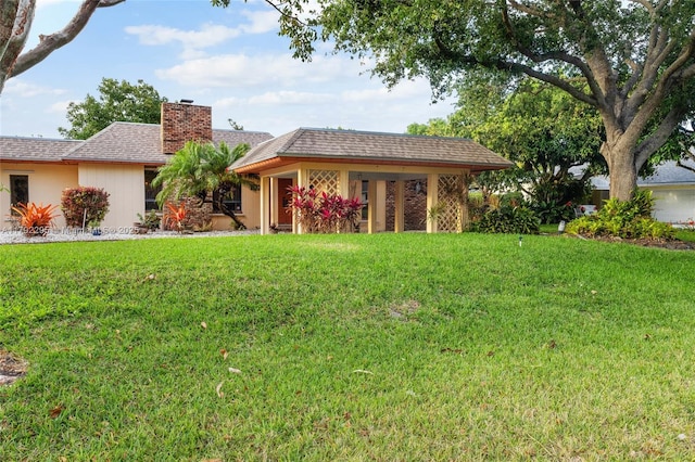 ranch-style home featuring a front lawn and a chimney