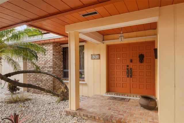 entrance to property featuring board and batten siding and visible vents