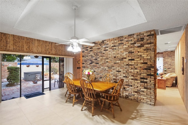dining space featuring wooden walls, brick wall, and ceiling fan