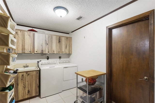 washroom with independent washer and dryer, cabinet space, a sink, a textured ceiling, and visible vents