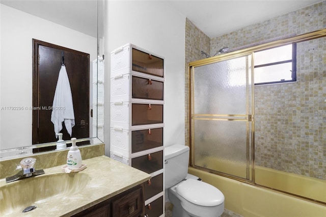 bathroom with vanity, combined bath / shower with glass door, and toilet