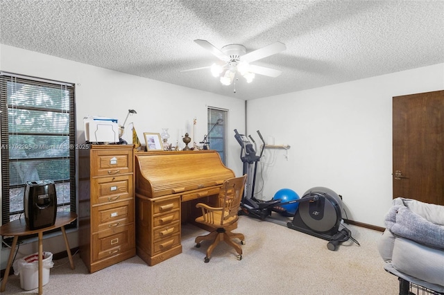 office area featuring a ceiling fan, a textured ceiling, and light carpet