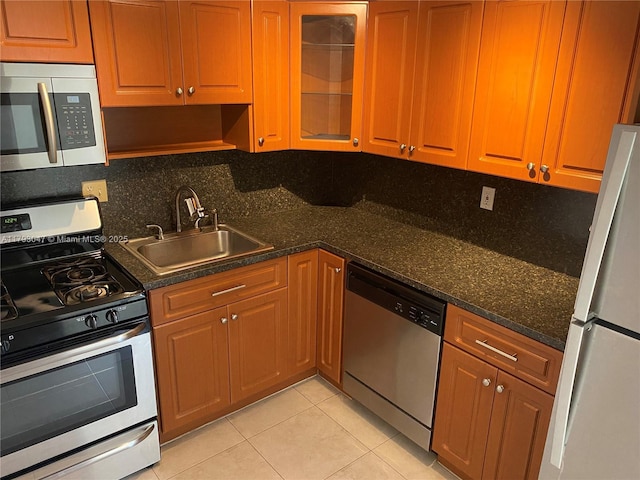 13120 SW 92nd Ave Unit B-222, Miami, FL 33176 - kitchen featuring tasteful backsplash, a sink, light tile patterned floors, glass insert cabinets, and stainless steel appliances