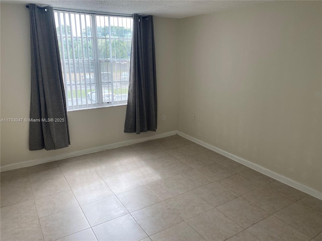 13120 SW 92nd Ave Unit B-222, Miami, FL 33176 - empty room with a textured ceiling, tile patterned floors, and a healthy amount of sunlight
