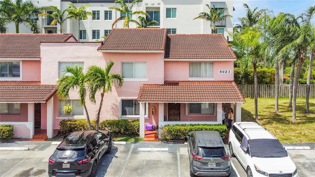 8023 Lake Dr Unit 201, Doral, FL 33166 - view of front of home featuring fence, uncovered parking, a tile roof, and stucco siding