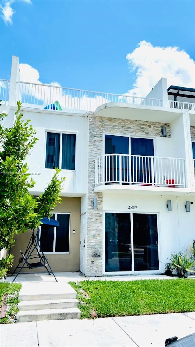 25836 SW 139th Path, Homestead, FL 33032 - rear view of property with stucco siding, stone siding, and a balcony