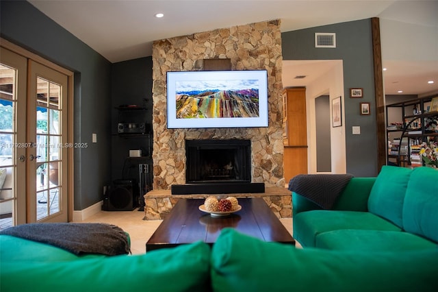 living room with visible vents, baseboards, a stone fireplace, recessed lighting, and vaulted ceiling