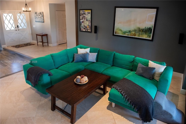 living area with baseboards and a chandelier