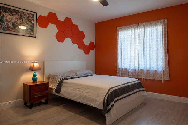 bedroom featuring baseboards, ceiling fan, and wood finished floors